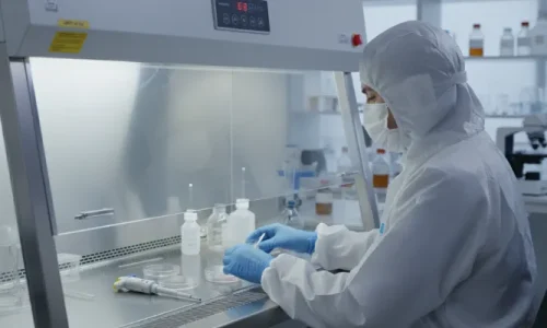 Technician working under a laminar flow hood